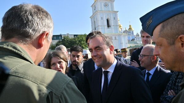 Министр обороны Франции Себастьян Лекорню (в центре) обращается с прессой на фоне Михайловского Златоверхого собора в Киеве