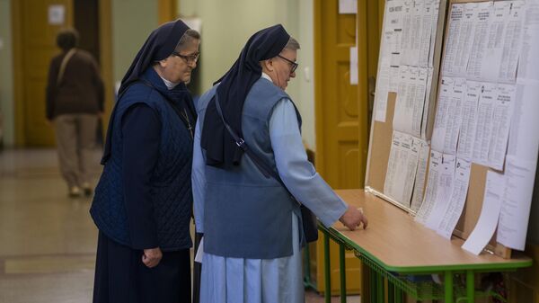 Католические монахини смотрят списки кандидатов на избирательном участке в Братиславе в Словакии. 30 сентября 2023