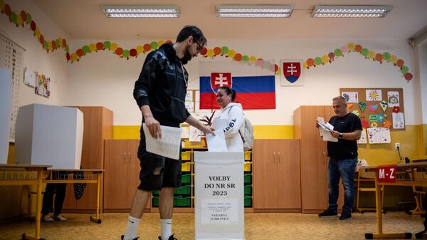 Мужчина опускает свой бюллетень в урну на избирательном участке в Братиславе в Словакии. 30 сентября 2023