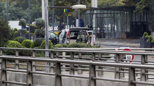 Турецкие полицейские и силы безопасности оцепляют территорию рядом с автомобилем после взрыва в Анкаре. 1 октября 2023