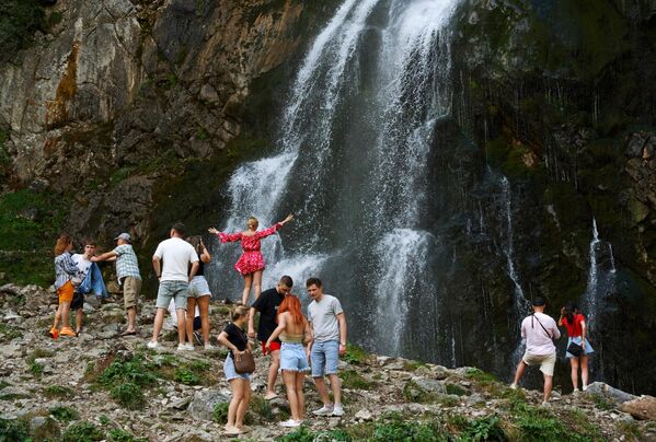 Туристы у Гегского водопада высотой около 70 метров, расположенный в северных отрогах Гагрского хребта на высоте 530 метров над уровнем моря в Абхазии