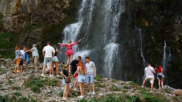 Туристы у Гегского водопада высотой около 70 метров, расположенный в северных отрогах Гагрского хребта на высоте 530 метров над уровнем моря в Абхазии