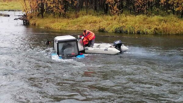 Спасатели оказывают помощь мужчине, пытавшемуся пересечь реку Кирганик на тракторе