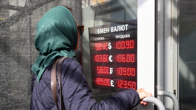 Женщина заходит в пункт обмена валюты в Москве