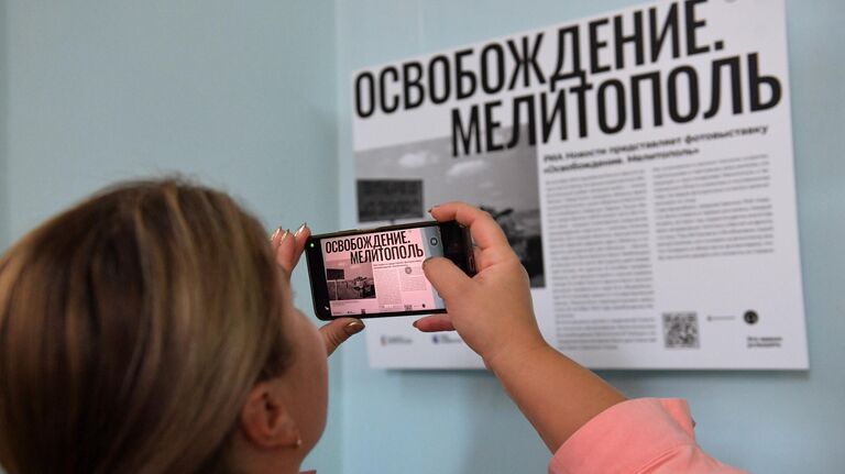 Посетительница фотовыставки Освобождение. Мелитополь в городском краеведческом музее Мелитополя