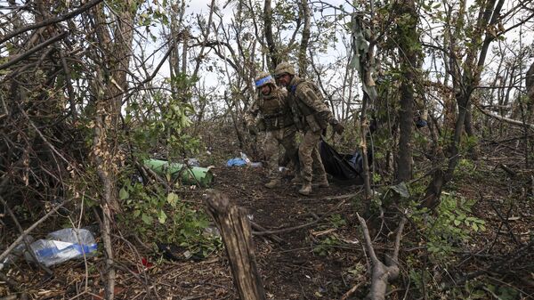 Украинские военнослужащие несут мешок с трупом убитого украинского солдата в Донецкой области