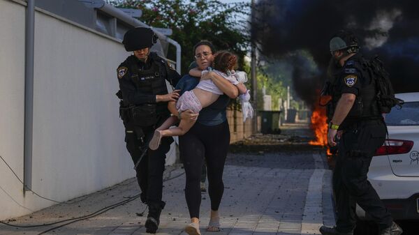 Сотрудники израильской полиции эвакуируют жителей в Ашкелоне