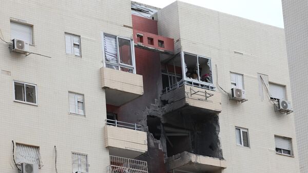 Вид разрушений в южном городе Ашкелон 9 октября 2023 года после того, как ночью в здание попала ракета из сектора Газа
