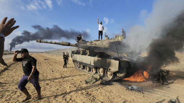 Палестинцы на подбитом израильском танке на границе Израиля и сектора Газа
