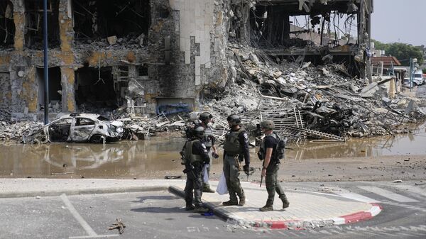 Израильские полицейские на фоне разрушенного здания в Сдероте