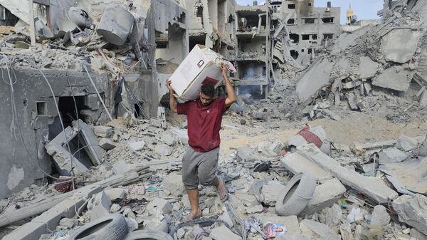 Житель сектора Газа у зданий, разрушенных в результате израильских авиаударов