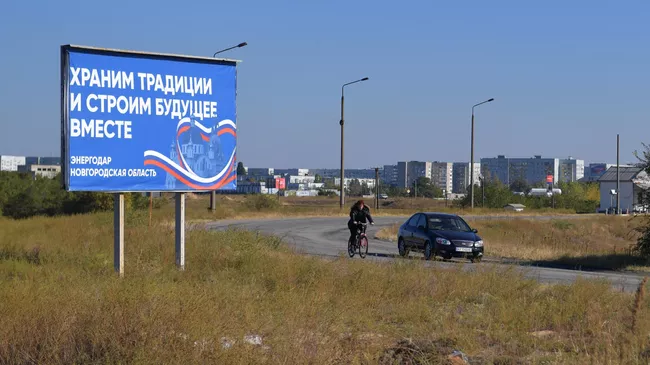 Щит с надписью Храним традиции и строим будущее вместе на въезде в Энергодар