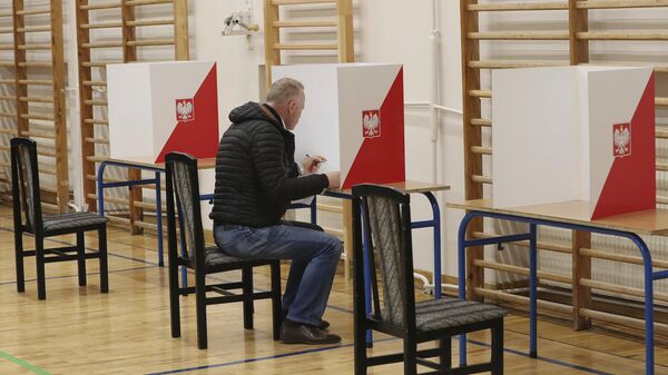 Мужчина голосует на парламентских выборах в Польше на избирательном участке в Варшаве