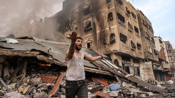 Мужчина около зданий, разрушенных в результате израильских ракетных ударов по Газе