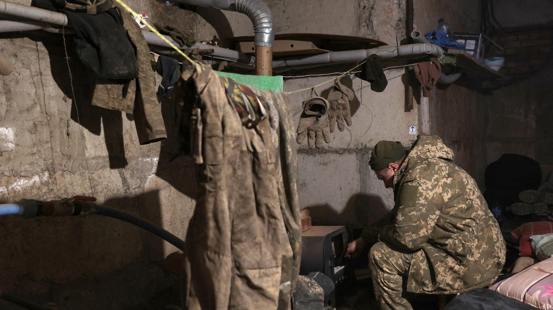 Украинский военнослужащий греется в землянке1