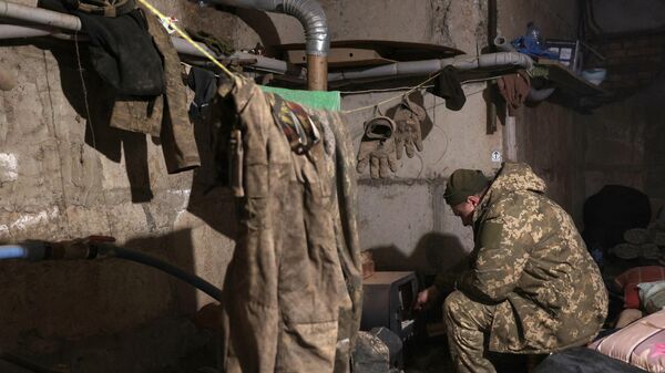 Украинский военнослужащий греется в землянке