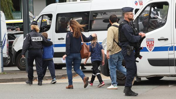 Представители полиции Франции и местные жители недалеко от лицея Гамбетта в Аррасе во Франции. 13 октября 2023