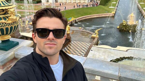 Джексон Хинкл позирует на фоне фонтанов в Петергофе во время поездки в Россию