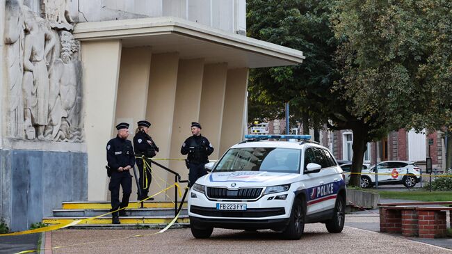 Полицейские офицеры возле лицея Гамбетта в Аррасе на северо-востоке Франции, где накануне был убит учитель и ранены несколько человек. 14 октября 2023