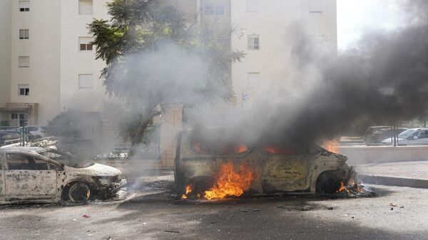 Горящие автомобили после попадания в них ракет из сектора Газа в Ашкелоне