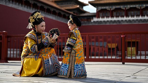 Женщина и девочка в традиционных китайских костюмах в Пекине