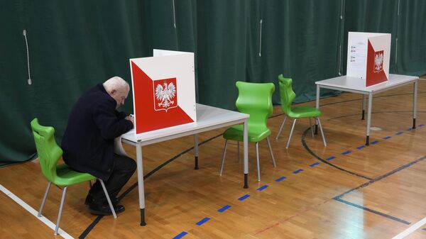 Мужчина голосует на парламентских выборах в Варшаве