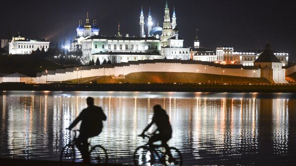 Молодые люди катаются на велосипедах по набережной реки Казанки