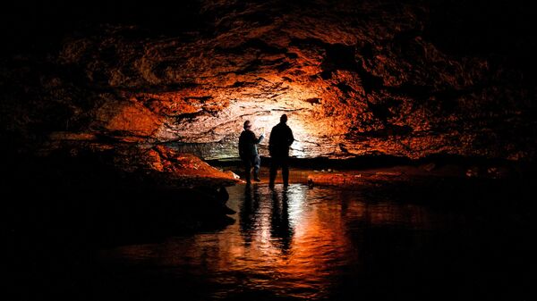 Посетители в пещере Певческая эстрада в Пинежском районе Архангельской области