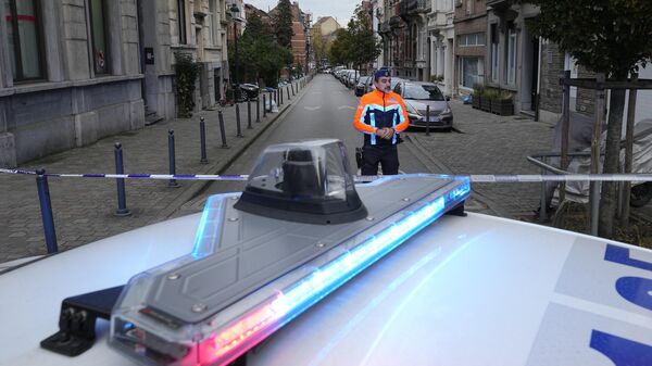 Бельгийский полицейский недалеко от места в Брюсселе, где был застрелен подозреваемый в нападении на болельщиков