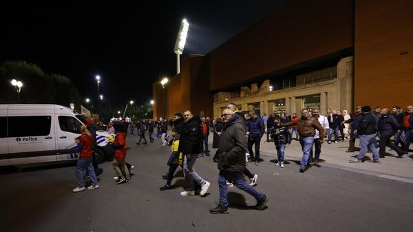 Болельщики покидают стадион после приостановки футбольного матча отборочного турнира Евро-2024 в группе F между сборными Бельгии и Швеции на стадионе Кинг Бодуэн в Брюсселе
