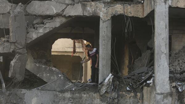 Палестинец в разрушенном израильским авиаударом доме в городе Хан-Юнис на юге сектора Газа