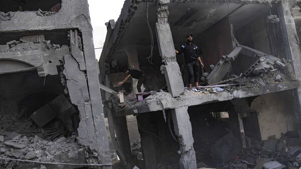 Палестинцы ищут выживших в здании, разрушенном в результате израильской бомбардировки в секторе Газа