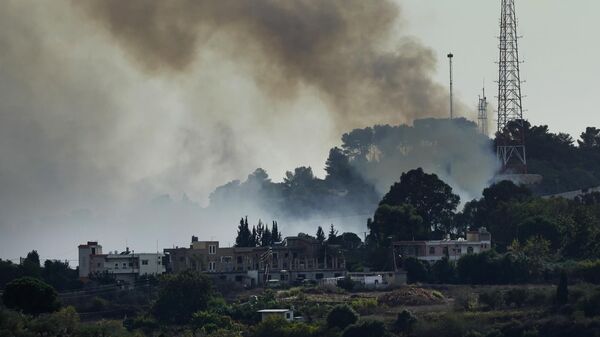 Дым над позицией израильской армии, которую атаковали боевики Хезболлы возле Альма аль-Шааб, ливанской пограничной деревни с Израилем
