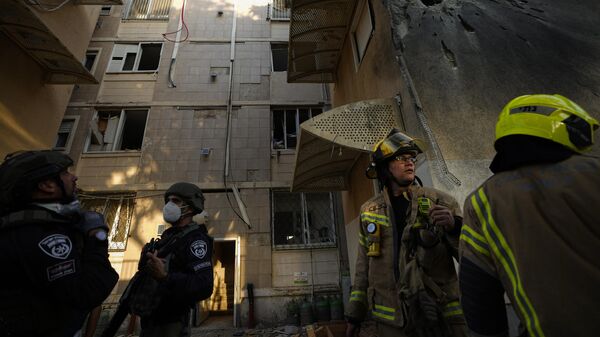 Израильские силы безопасности возле поврежденного жилого дома после попадания в него ракеты, выпущенной из сектора Газа, в Сдероте