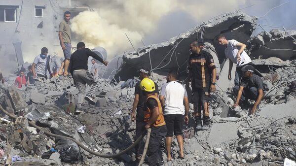 Палестинцы ищут выживших среди развалин дома после израильского авиаудара по сектору Газа
