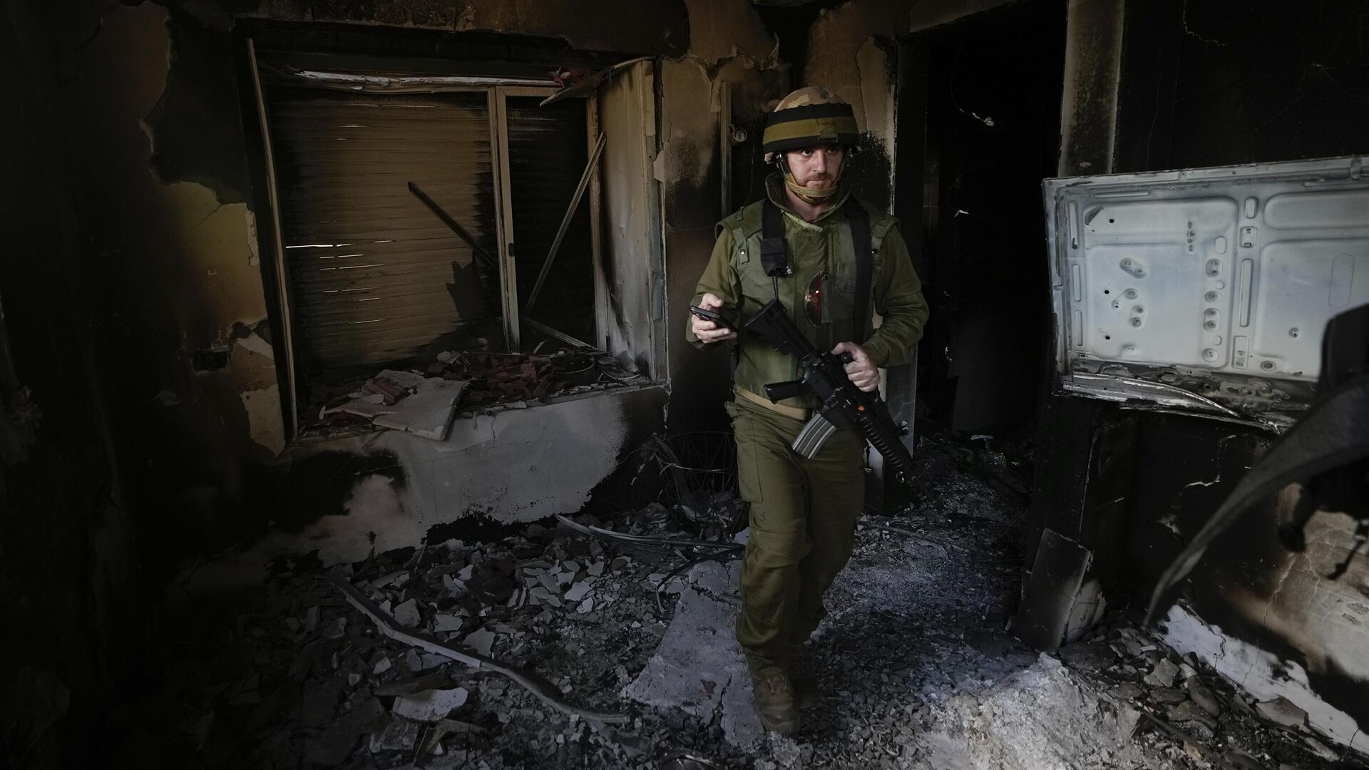 Израильский солдат осматривает дом, поврежденный боевиками Хамаса в кибуце Беэри в Израиле - РИА Новости, 1920, 19.10.2023