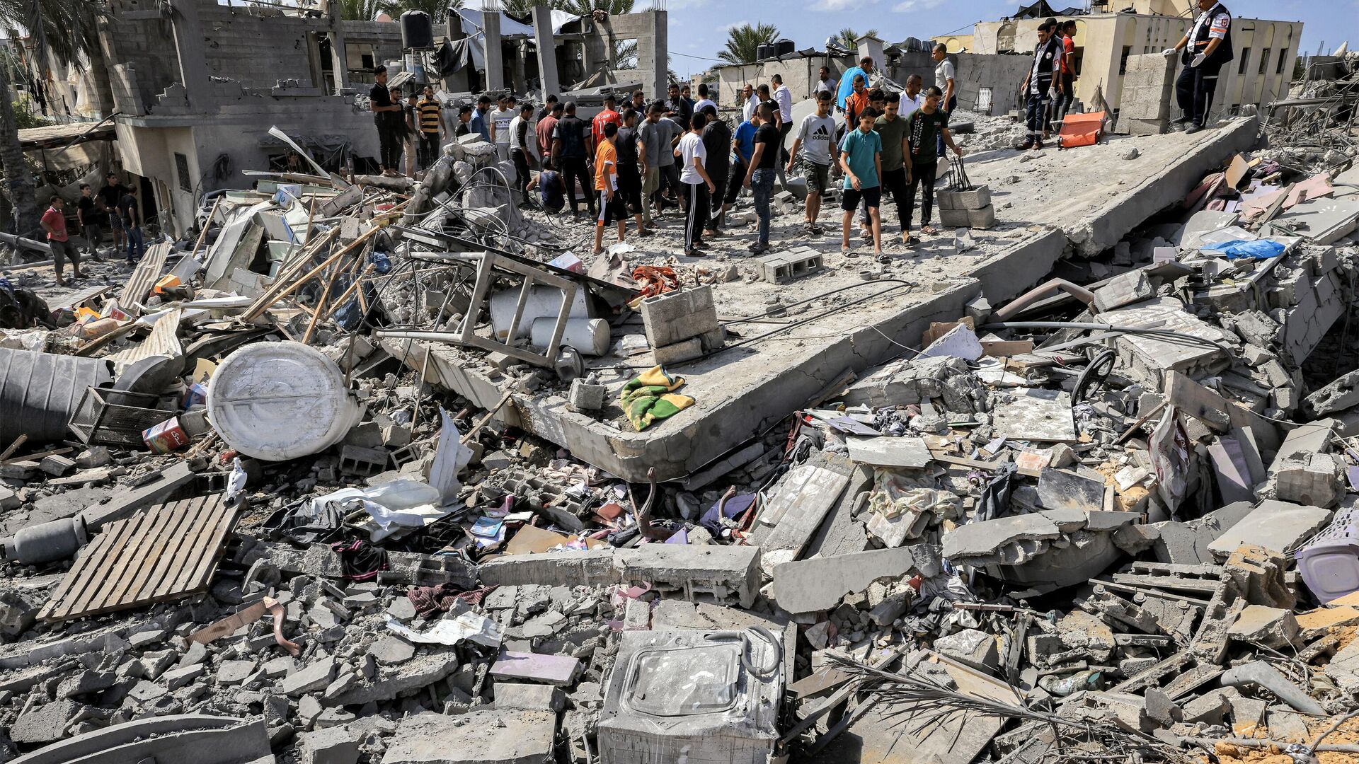 Люди на месте разрушенного после израильской бомбардировки здания в Хан-Юнисе на юге сектора Газа - РИА Новости, 1920, 18.10.2023