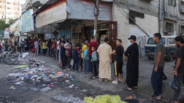 Палестинцы стоят в очереди за хлебом в пекарне в Рафахе на юге сектора Газа