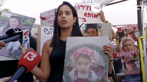 Девушка, сбежавшая из кибуца на юге Израиля во время нападения ХАМАС, во время митинга в Тель-Авиве