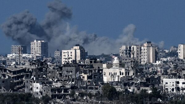 Дым над разрушенными зданиями в северо-западной части сектора Газа во время израильской бомбардировки