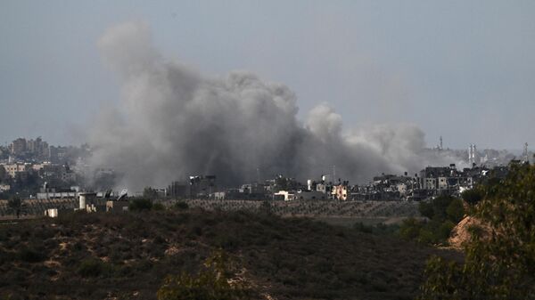 Дым над разрушенными зданиями в северной части сектора Газа во время израильской бомбардировки