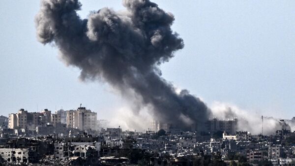 Дым над зданиями в секторе Газа во время израильского удара