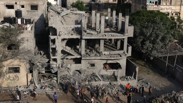 Палестинцы около разрушенных от ночных израильских ударов зданий в Рафахе на юге сектора Газа