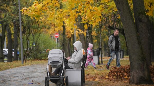 Женщина с детской коляской в сквере на улице Крупской в Москве