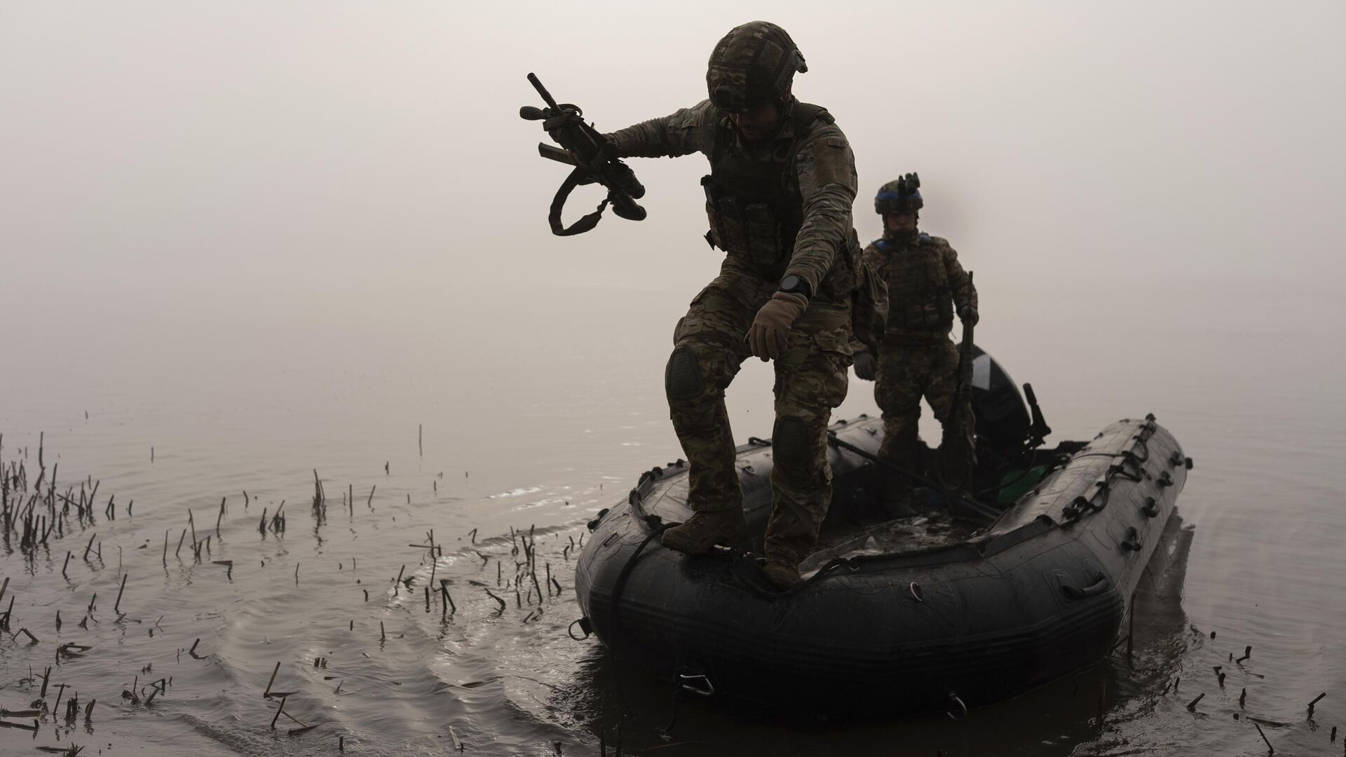 Украинский военнослужащий выпрыгивает из лодки на берег Днепра - РИА Новости, 1920, 16.12.2023