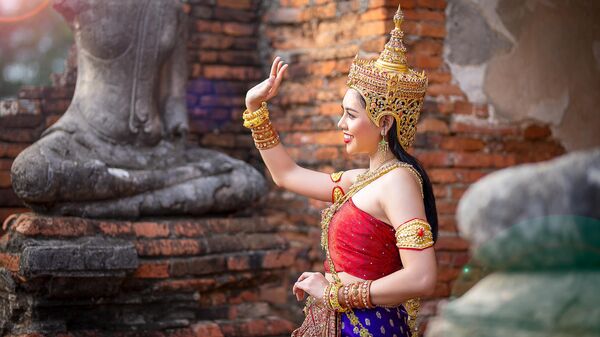 Танцовщица в традиционной тайской одежде на территории исторического города Аютайя