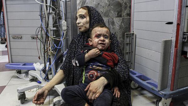 Пострадавшие от израильского обстрела женщина с ребенком в больнице Аль-Шифа в Газе
