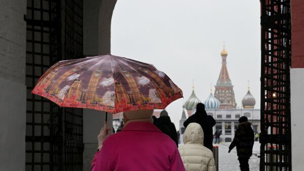 Женщина во время дождя на Красной площади в Москве