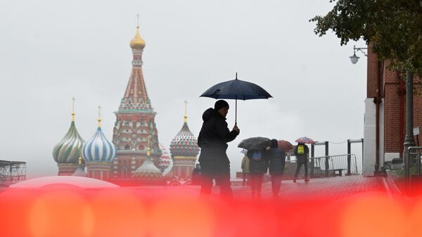 Мужчина во время дождя на Красной площади в Москве