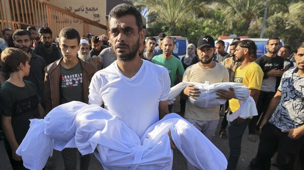 Родители несут тела детей, погибших при обстреле сектора Газа со стороны Израиля